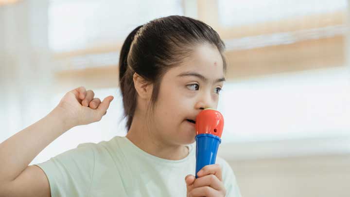 Autistic girl delivering a speech in her classroom to improve communication skills.