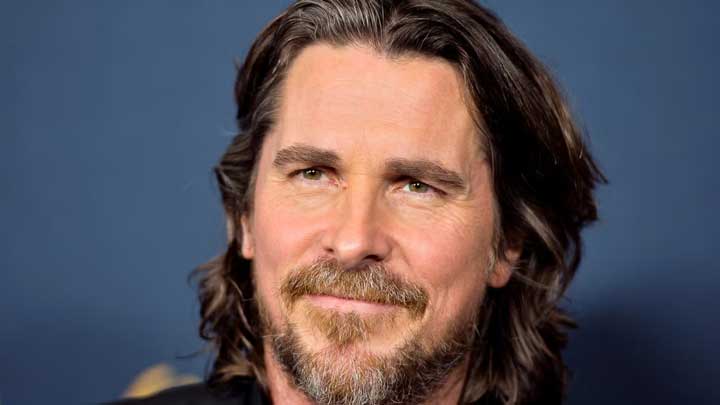 Christian Bale posing confidently for the camera, highlighting his journey of overcoming behavioral challenges linked to Conduct Disorder.