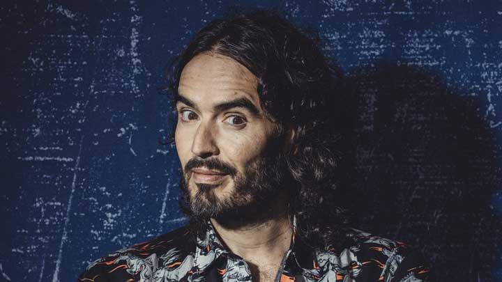 Russell Brand posing confidently for the camera, highlighting his journey with Bipolar Disorder.