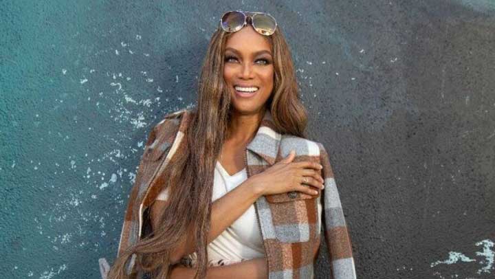 Tyra Banks posing confidently for a photographer in a casual outfit, symbolizing her journey of managing Specific Phobias.